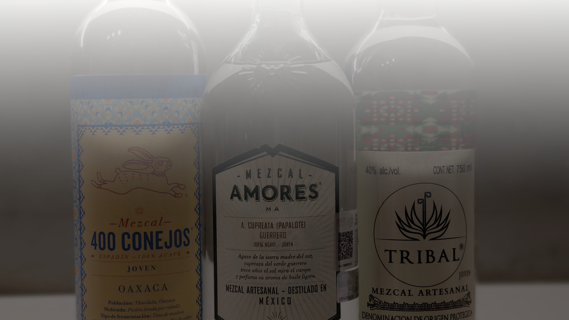 Traditional Mexican mezcal glass filled with golden spirit on rustic wood